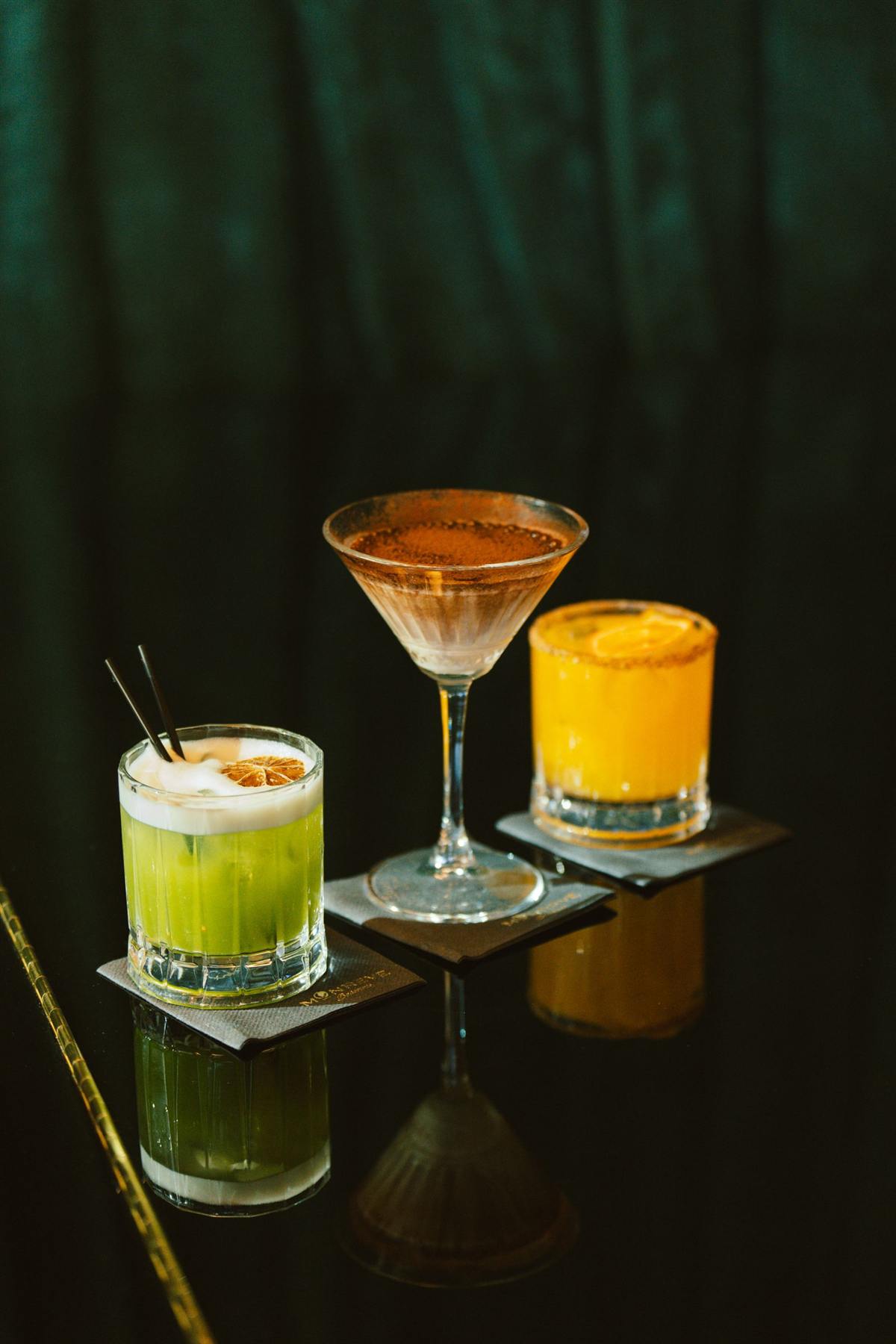 Trois cocktails servis sur un comptoir sombre (photo d’illustration)