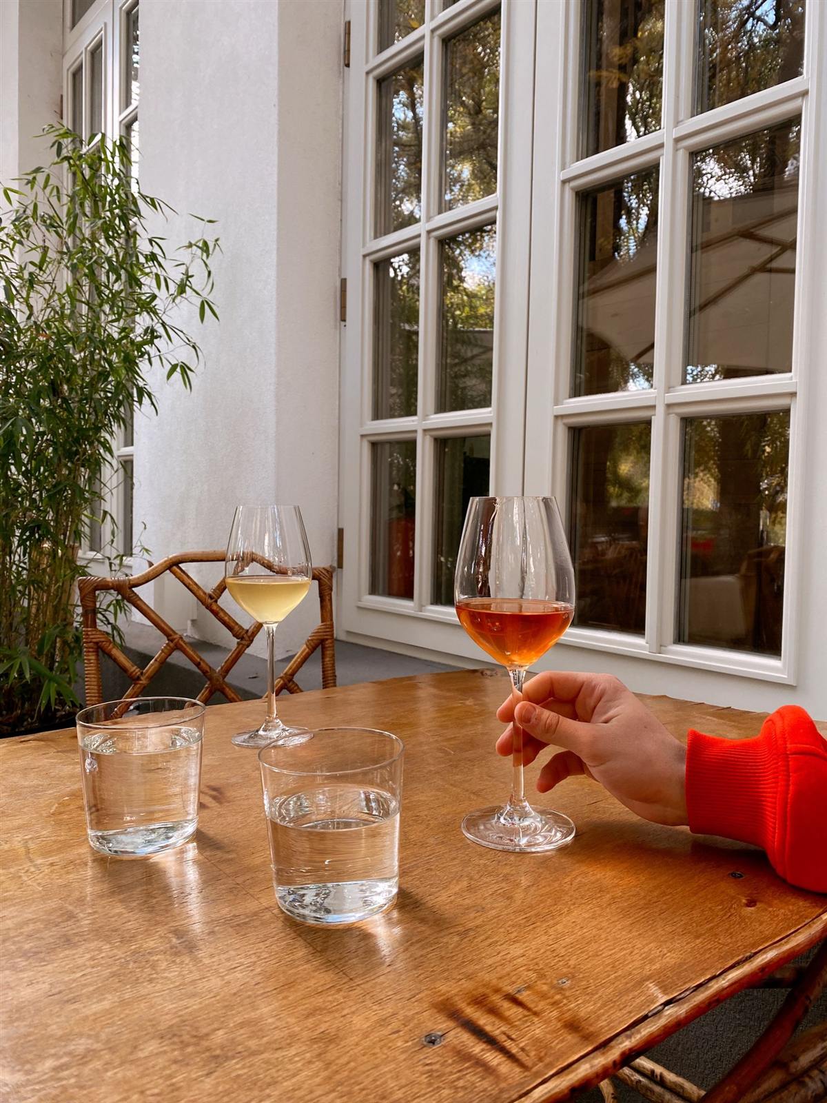 Table en bois près d’une fenêtre, verres posés pour le déjeuner (photo d’illustration)
