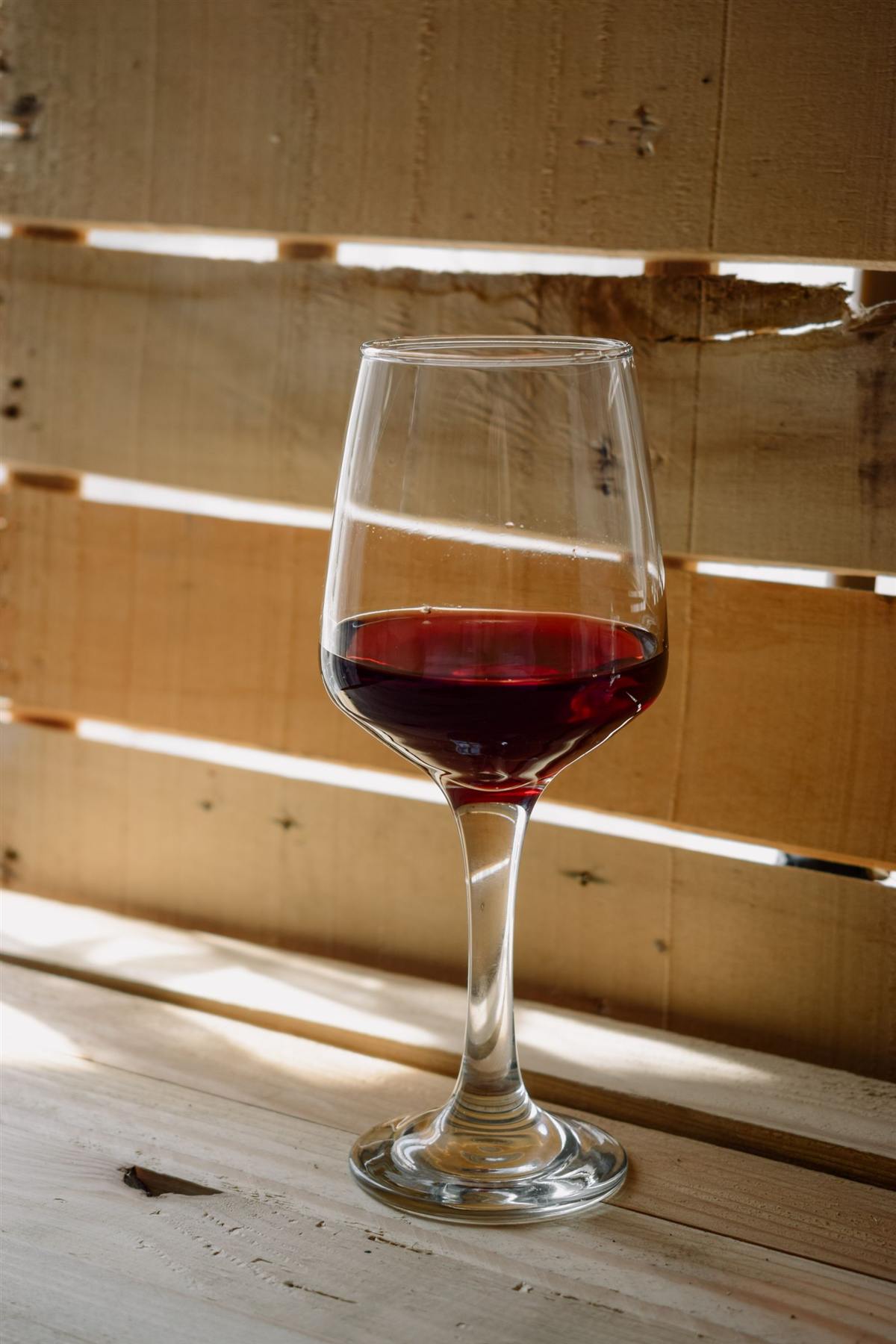 Verre de vin rouge posé sur une table en bois (photo d’illustration)